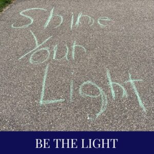 Child's sidewalk chalk drawing saying Shine Your Light.